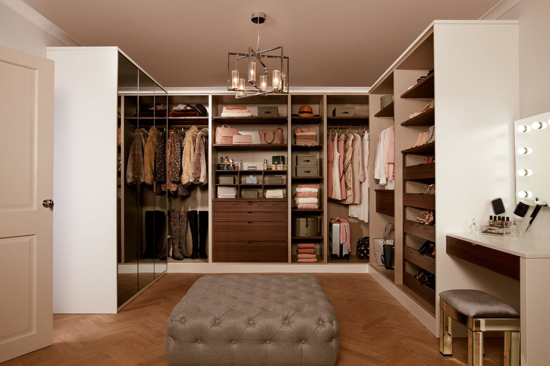 Walk-in dressing room in white and walnut with an upholstered ottoman