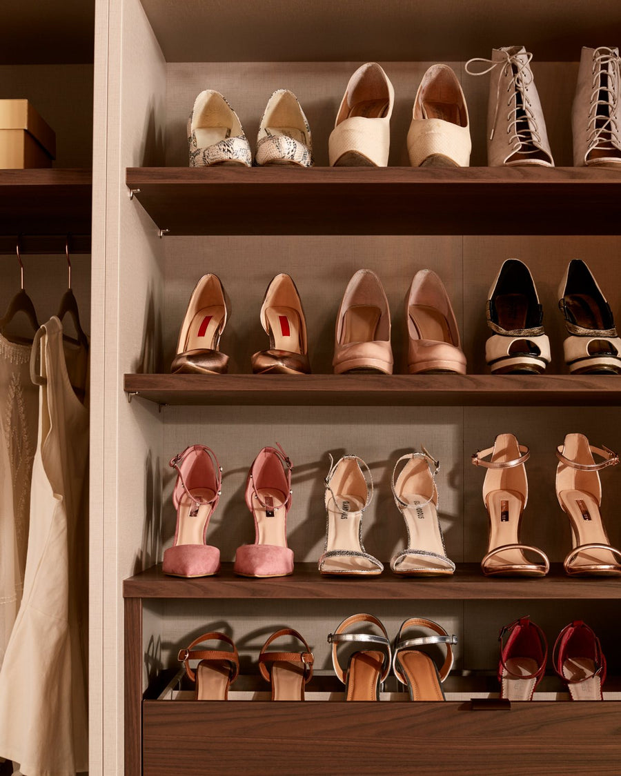 Walnut shoe shelves and hanging in a walk-in wardrobe