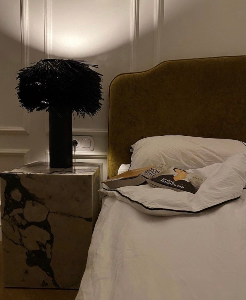 Mustard velvet headboard beside a marble side table